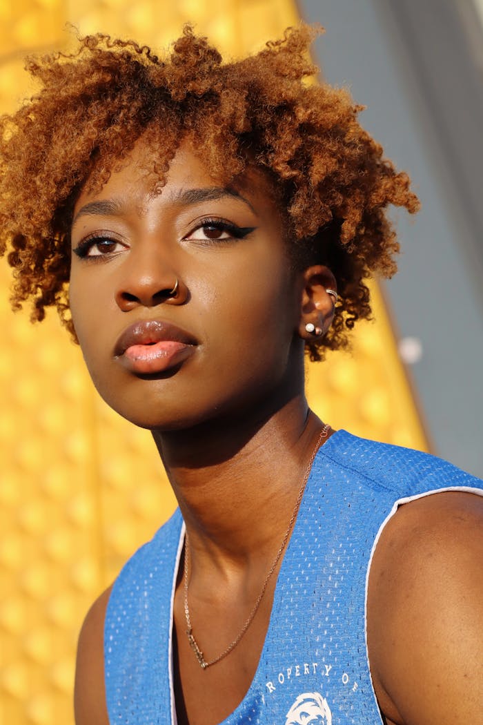 Portrait of a stylish woman with curly hair in bright sunlight, Berlin.